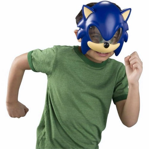 A young child wearing a green t-shirt and a TOMY Sonic Boom Role Play Mask - Sonic, playfully posing with one arm raised as if running.